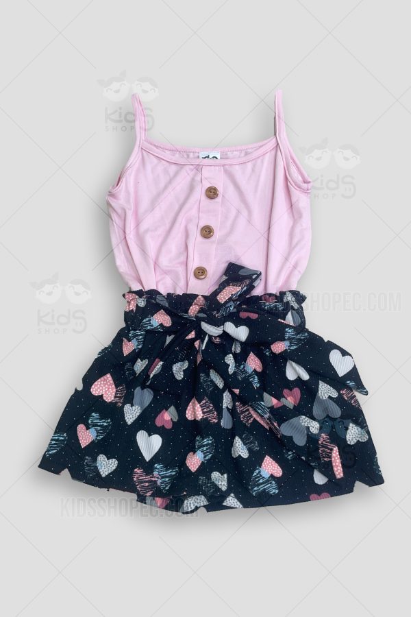 Blusa rosa de tirantes y un short negro con lazo en cintura.