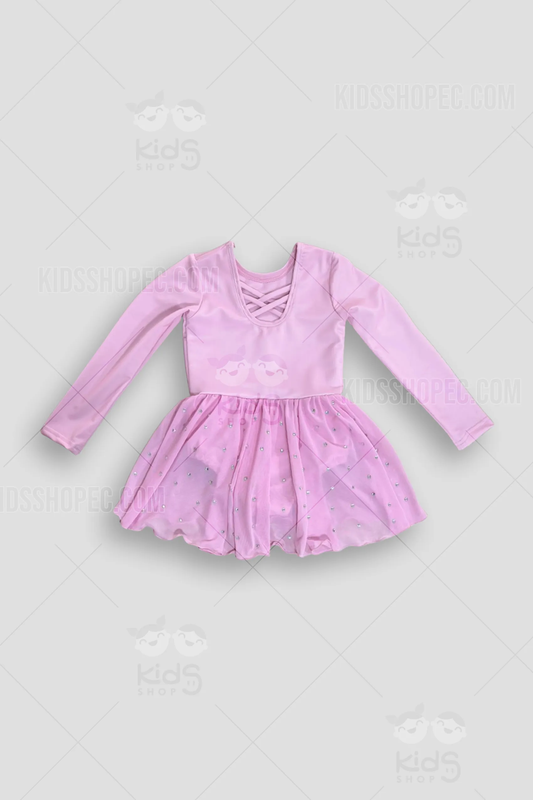 Fotografía frontal y trasera de un vestido de danza para niña en color rosa pastel sólido. El corpiño tiene cuello redondo y mangas largas. La parte trasera destaca por un elegante diseño de múltiples tiras cruzadas en la espalda. La falda fluida está confeccionada en una suave malla transparente y se encuentra decorada con pequeños cristales brillantes (pedrería) esparcidos por toda la tela. Debajo de la falda lleva un leotardo integrado del mismo color. Se exhibe sobre un fondo gris neutro con marcas de agua de Kids Shop EC.