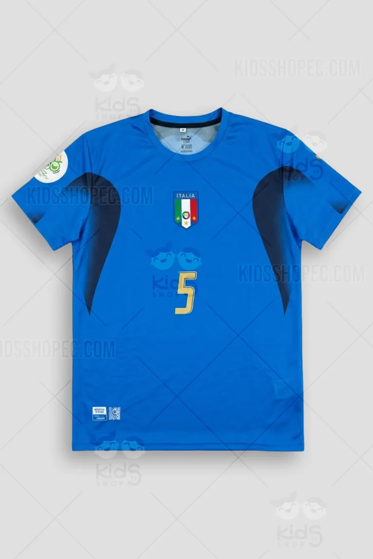 Fotografías de estudio en formato flat lay y primeros planos de una camiseta de fútbol retro color azul, inspirada en la equipación de la selección italiana campeona del mundo en 2006. La parte frontal presenta un cuello redondo, detalles curvos en azul marino oscuro en la zona de los hombros y axilas, el escudo con la bandera tricolor y la palabra "ITALIA" coronado por tres estrellas doradas, junto a un pequeño número 5 dorado en el centro. La espalda destaca por el apellido "CANNAVARO" en letras minúsculas estilizadas y un gran dorsal "5" en color dorado con una fina línea de contorno. Incluye parche temático en la manga.