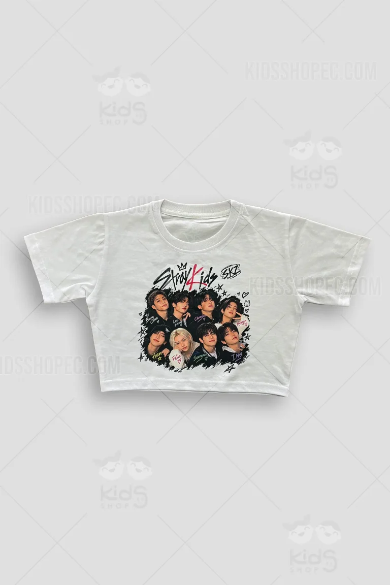 Fotografías de estudio en formato flat lay de una blusa corta o crop top de manga corta en color blanco. El panel frontal presenta un diseño gráfico de la banda de K-Pop Stray Kids, mostrando a los miembros del grupo, los logotipos "Stray Kids" y "SKZ" con una corona, y los nombres individuales de los artistas decorados con corazones sobre un fondo de trazos negros irregulares. La espalda es blanca lisa y muestra un pequeño logotipo "SKZ" negro en la parte superior central y una pequeña etiqueta decorativa en el dobladillo inferior izquierdo.