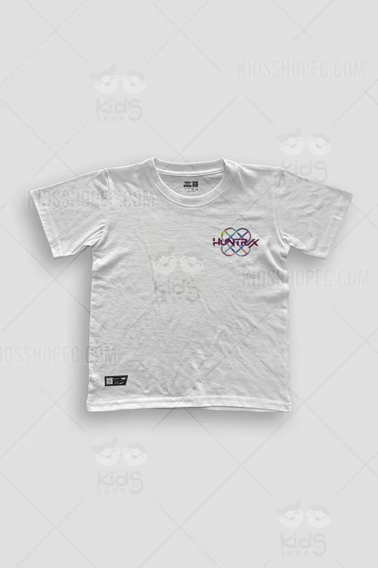 Fotografías de estudio en formato flat lay de una camiseta de manga corta en color blanco sólido con cuello redondo. La parte frontal muestra un logotipo en el pecho izquierdo con el texto "HUNTRX" sobre un símbolo geométrico entrelazado multicolor, acompañado de una etiqueta negra decorativa en el dobladillo inferior izquierdo. La parte posterior presenta un gran estampado principal que ilustra a tres chicas estilo K-pop animado y una mascota de gato azul, enmarcados dentro de una gran estrella morada con detalles de semitonos, coronado por la palabra "HUNTRX" en tipografía estilizada.