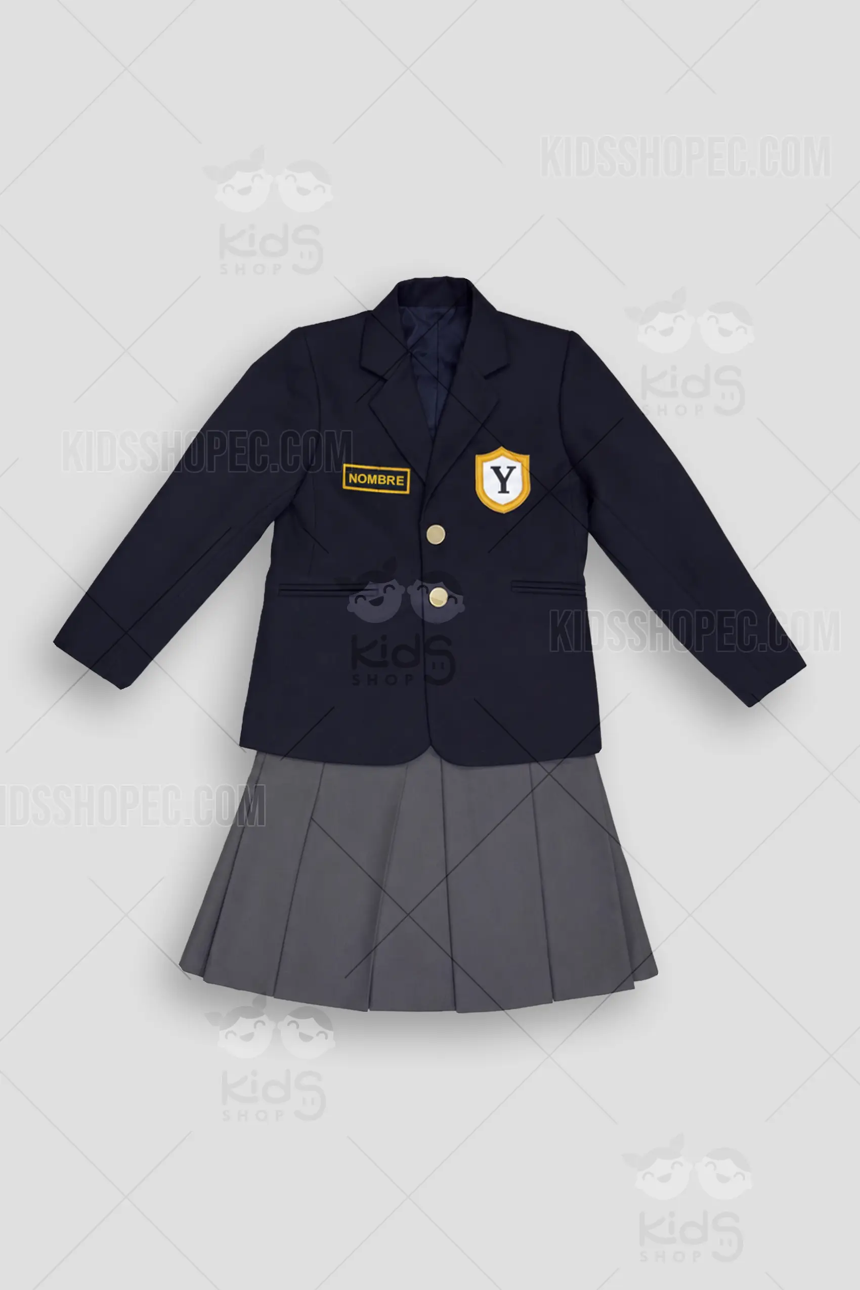 Fotografías de estudio en formato flat lay de un conjunto de uniforme escolar de dos piezas. Incluye una leva azul marino de manga larga con solapas clásicas, dos botones dorados frontales y falsos bolsillos con ribete. En el pecho izquierdo lleva un aplique en forma de escudo con la letra "Y" y bordes amarillos; en el derecho, un parche rectangular amarillo con la palabra "NOMBRE" en azul. Se complementa con una falda escolar plisada en color gris oscuro, con pretina lisa y cierre de botón lateral.