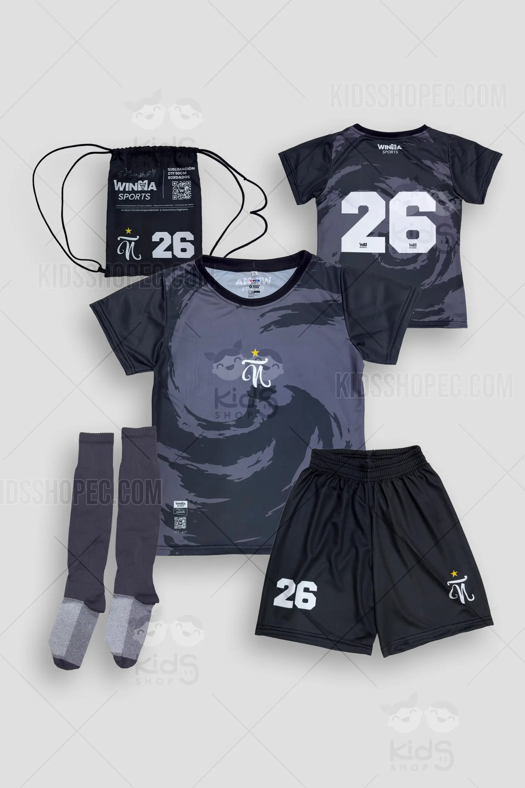 Fotografías de estudio en formato flat lay de un equipo de fútbol completo. Incluye una camiseta de manga corta con diseño sublimado de un patrón de remolinos en tonos gris oscuro y negro, luciendo un logotipo central blanco en forma de "N" estilizada con una estrella amarilla. La espalda muestra el número "26" y logotipos de patrocinadores en blanco. El set se complementa con una pantaloneta negra de cintura elástica que lleva el número "26" y el mismo logotipo; un par de medias deportivas gris oscuro con refuerzos claros en talón y punta; y una mochila deportiva de cordones (tula) negra con gráficos, textos informativos y el número "26".